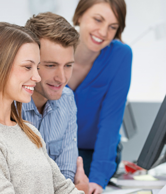 Junge junge Menschen am Schreibtisch vor dem Computer.